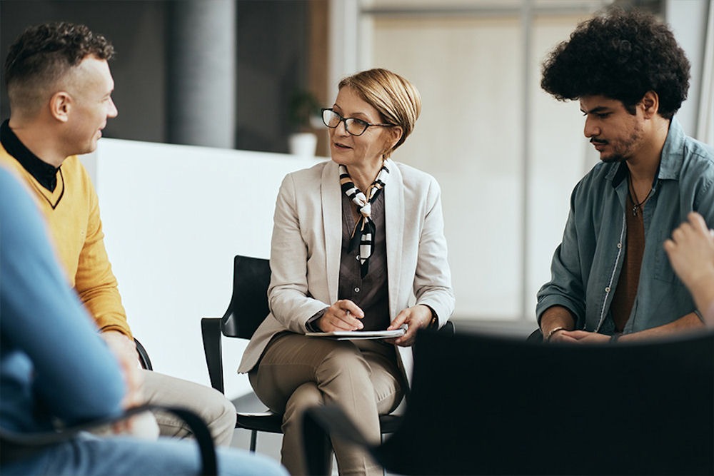 addiction-and-mental-health-treatment therapist leading group therapy session for men in addiction program
