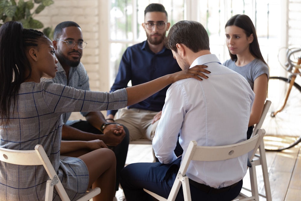 addiction-treatment-programs diverse group sitting in meeting for addiction treatment