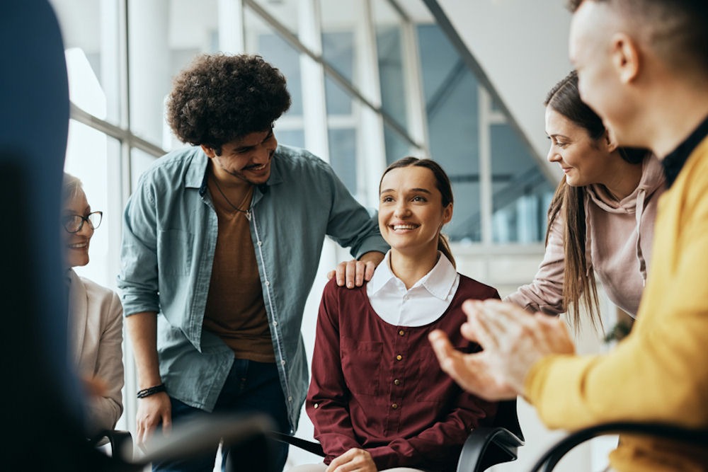 Mixed-gender support group congratulating young woman for completing medical detox