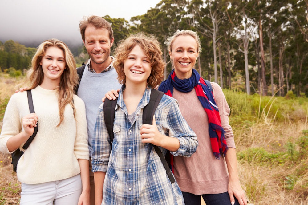 heal-from-addiction Group of a straight couple in their forties, a teenage woman, and a gender non-conforming child with the man's hand on their shoulder